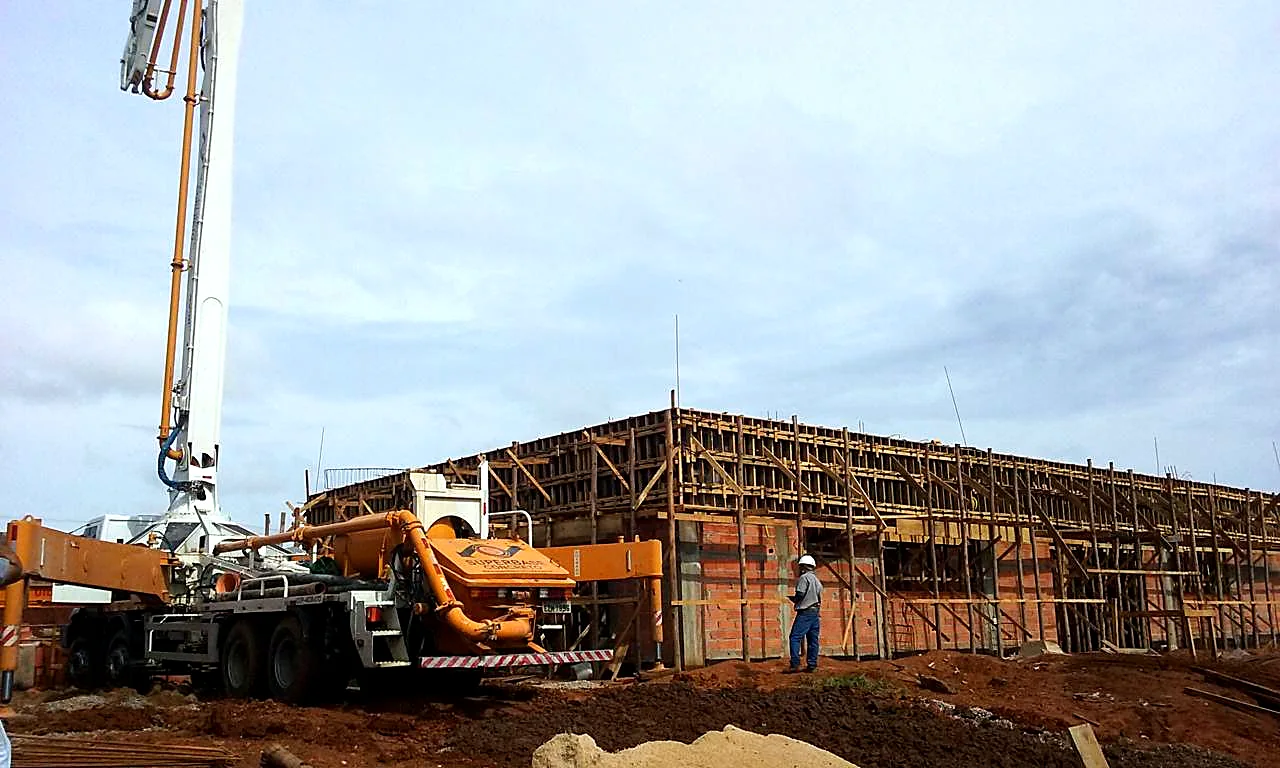 Caminhão bomba lança posicionado para concretagem de laje em obra públ Caminhão bomba lança posicionado para concretagem de laje em obra pública