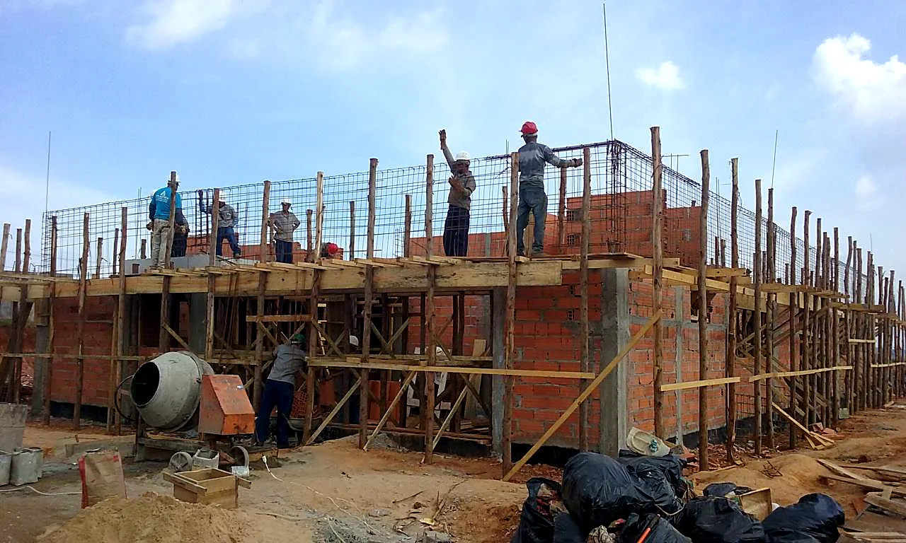 Equipe de obra trabalhando na armação de laje sobre alvenaria estrutur Equipe de obra trabalhando na armação de laje sobre alvenaria estrutural