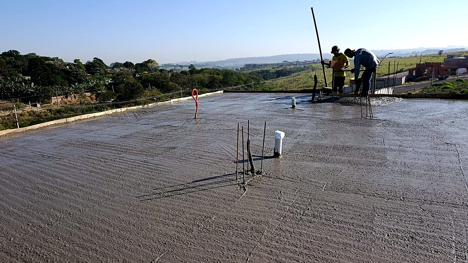 Laje recém concretada recebendo acabamento superficial pela equipe de Laje recém concretada recebendo acabamento superficial pela equipe de obra
