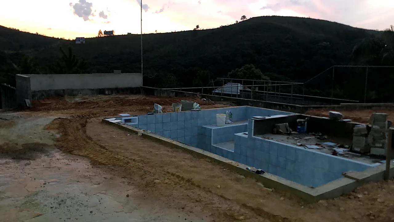 Piscina em concreto armado concluída em área externa de residência Piscina em concreto armado concluída em área externa de residência