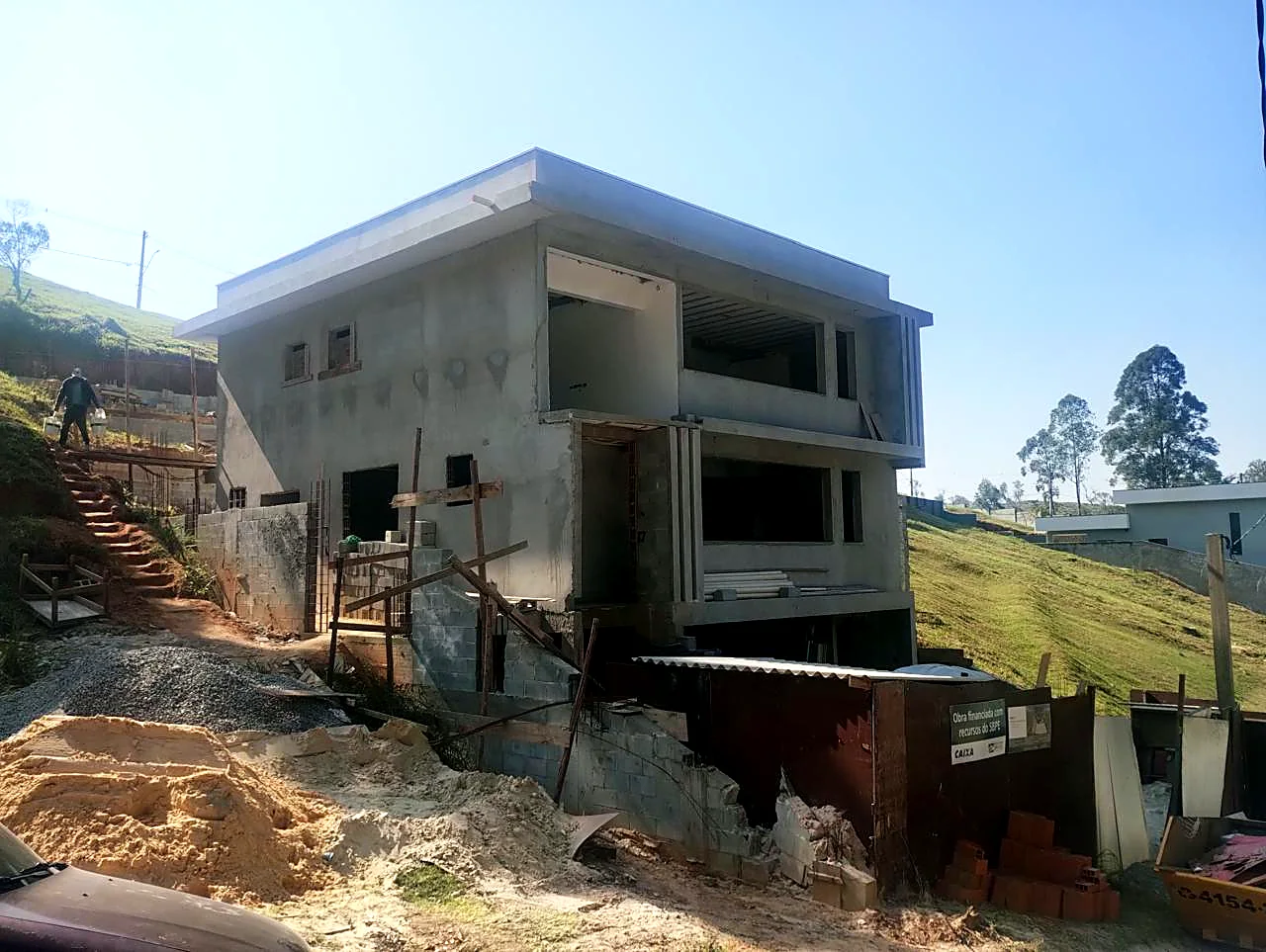 Residência em terreno com desnível e estrutura de concreto concluída Residência em terreno com desnível e estrutura de concreto concluída